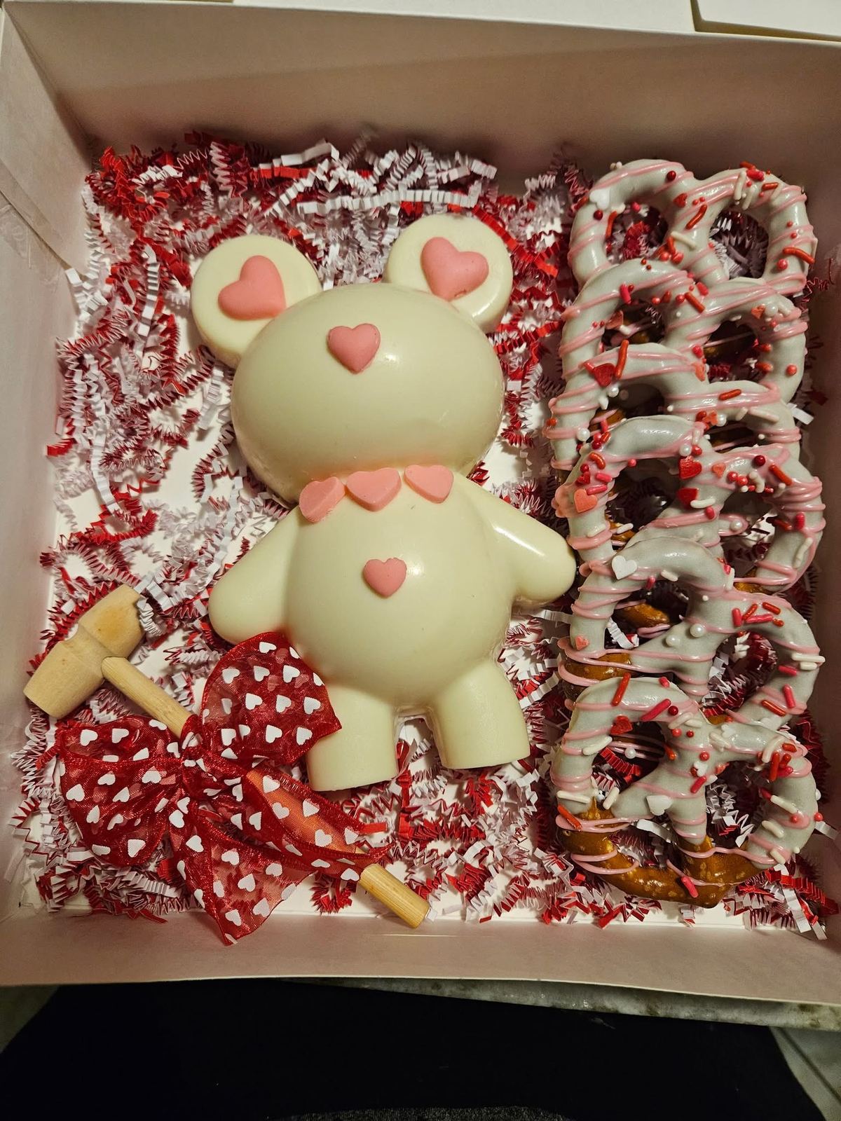 White chocolate bear favor beside chocolate-dipped pretzels
